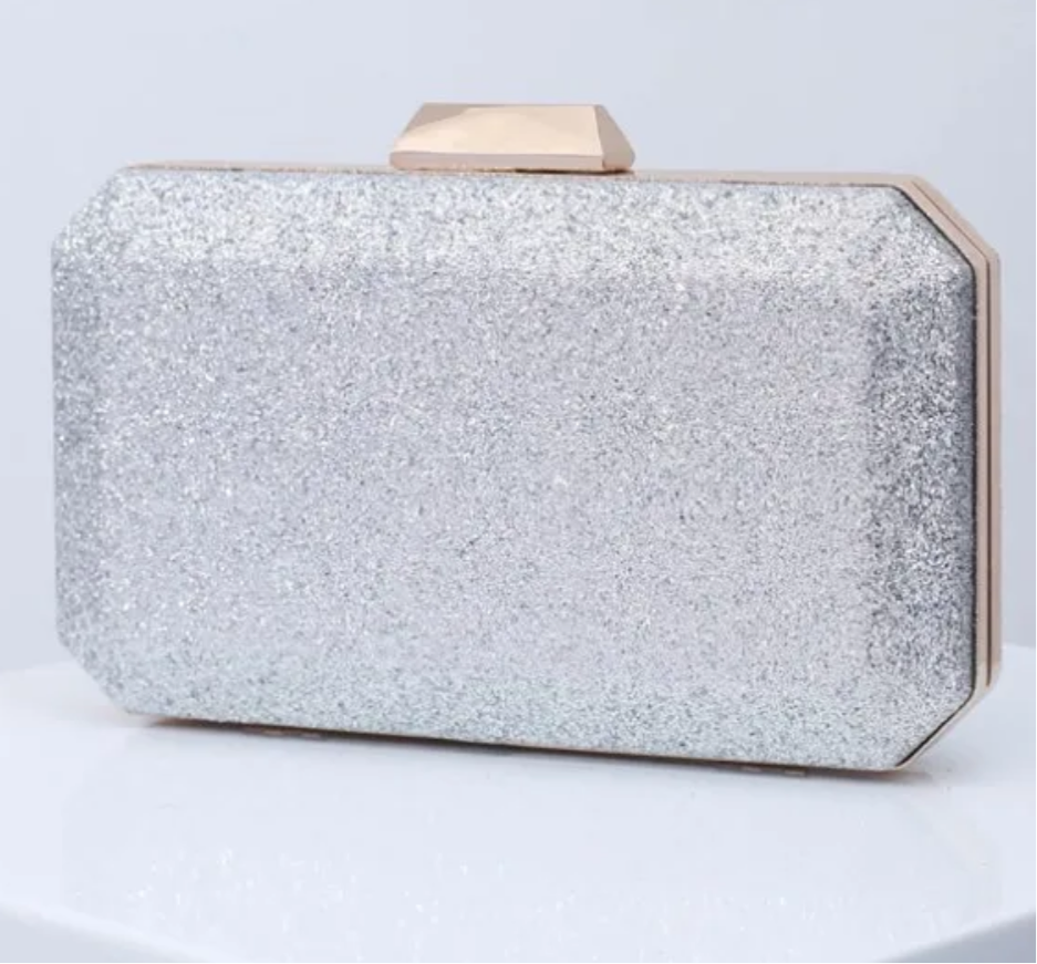 Pochette de soirée argentée avec paillettes et fermoir doré. Petite bandoulière en chaîne incluse, parfaite pour une touche glamour.